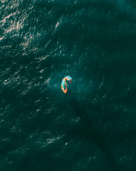 a person riding a surfboard on top of a body of water, view from the sky, orange and teal, thumbnail, dingy