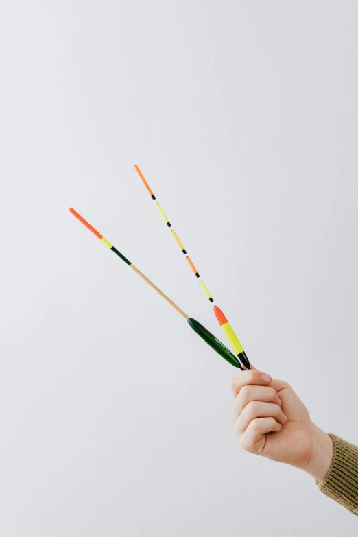 a person holding three arrows in their hand, inspired by Jan Rustem, unsplash, kinetic art, traditional japanese colors, fishing pole, 2 1 0 mm, with fluo colored details