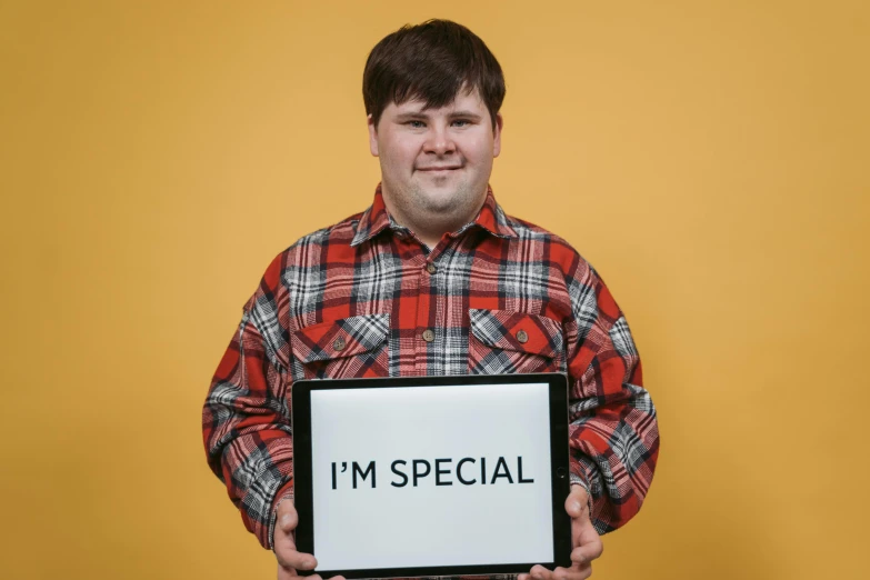 a man holding a sign that says i'm special, an album cover, inspired by Dan Content, pexels, jontron, ability image, holding notebook, studio portrait photo