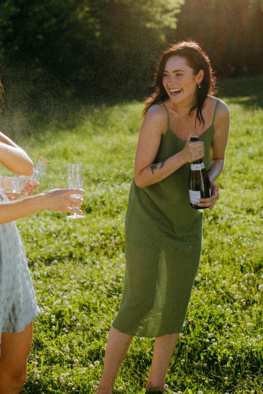 a group of women standing on top of a lush green field, bubbly, pouring, charcoal and champagne, feature