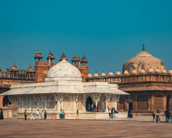 a group of people standing in front of a building, by Julia Pishtar, pexels contest winner, with great domes and arches, india, ivory and copper, parks and monuments