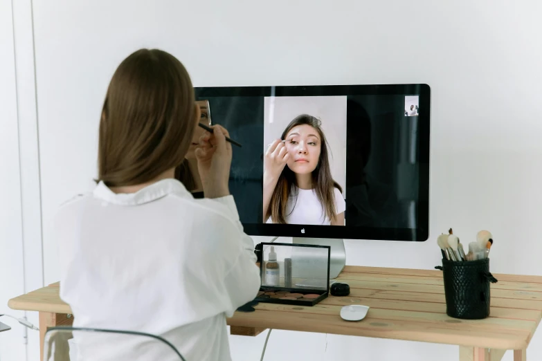 a woman sitting at a desk in front of a computer, trending on pexels, hyperrealism, doctors mirror, with professional makeup, photo booth, instagram post