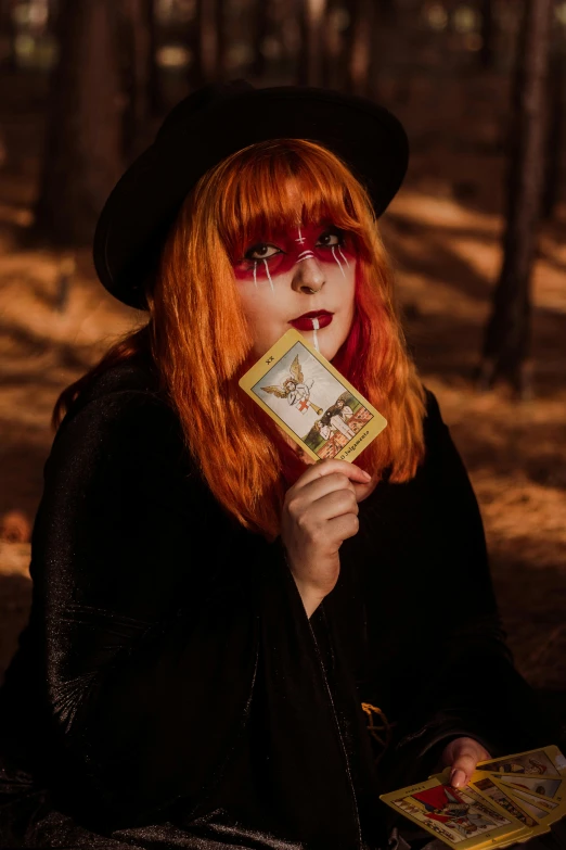 a woman with red hair holding a tarot, pexels contest winner, beautiful cowboy witch, mod, halloween, taken in the early 2020s