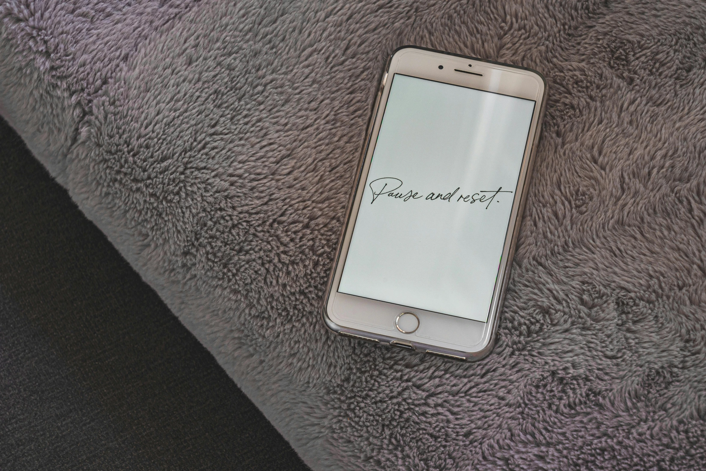 a close up of a cell phone on a blanket, an album cover, pexels, “modern calligraphy art, velvet couch, white and grey, beautiful iphone wallpaper