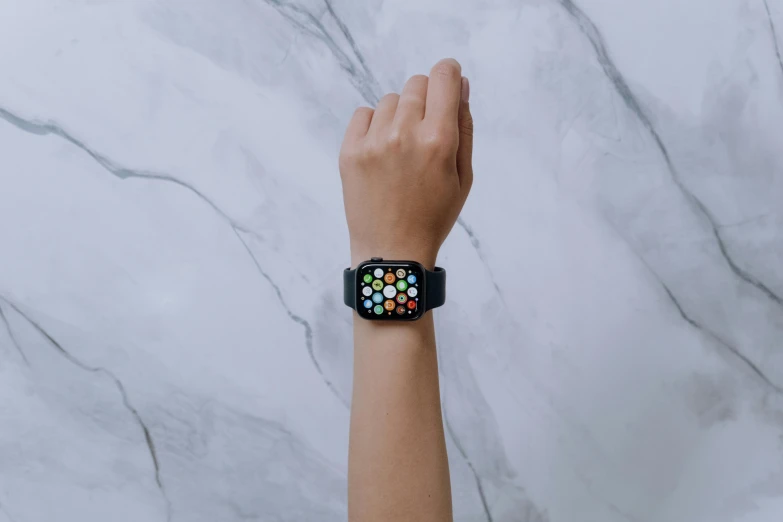 a person with an apple watch on their wrist, a hyperrealistic painting, by Julia Pishtar, trending on pexels, colored dots, on a large marble wall, background image, multi - coloured