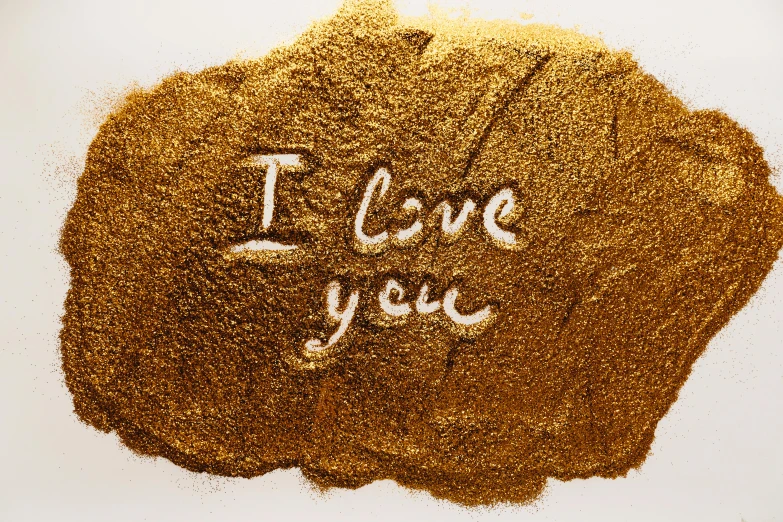 a pile of sand with the words i love you written on it, by Julia Pishtar, gold paint, 1647, powder, profile picture