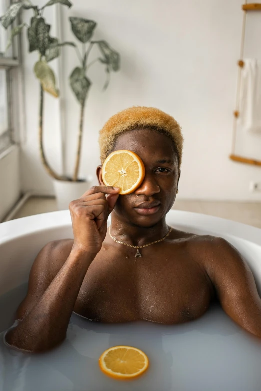 a man in a bathtub holding a slice of orange, by Cosmo Alexander, trending on pexels, short blonde afro, postprocessed), black people, monocle