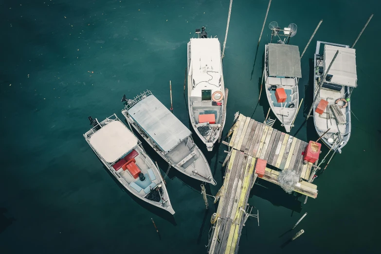 a group of boats sitting on top of a body of water, pexels contest winner, hurufiyya, grey, overhead, docks, thumbnail