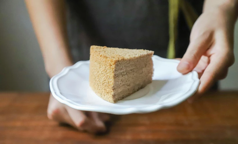 a person holding a plate with a piece of cake on it, inspired by Richmond Barthé, unsplash, beige, sponge, thick lining, tall