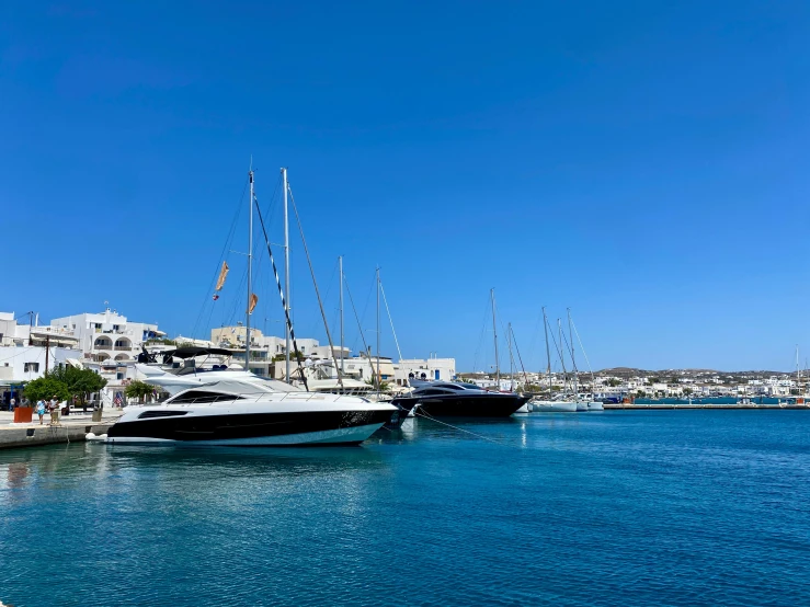 a number of boats in a body of water, pexels contest winner, clear blue skies, whitewashed buildings, relaxing on a yacht at sea, moored