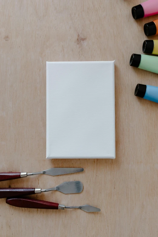 a wooden table topped with different colored crayons, a minimalist painting, inspired by Kyffin Williams, unsplash, made of all white ceramic tiles, on canvas, miniature product photo, paint knife