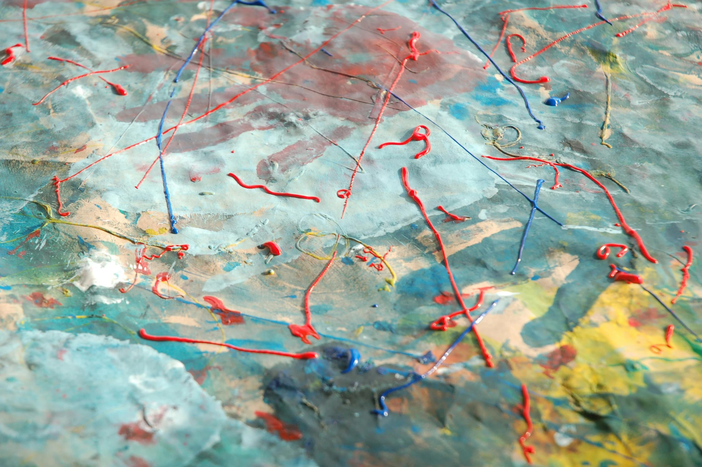 a close up of a painting on a table, inspired by Pollock, flickr, action painting, azure and red tones, muted blue and red tones, music, birdseye view