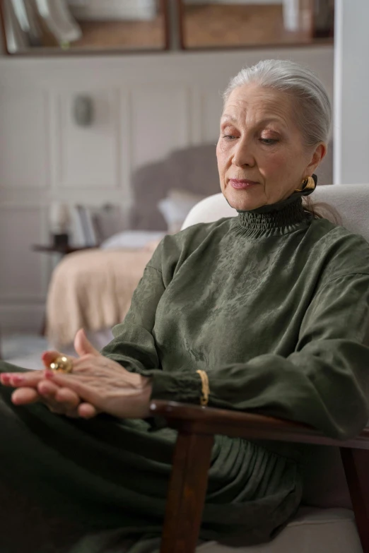 a woman sitting in a chair in a room, anjali mudra, older woman, netflix, paul barson