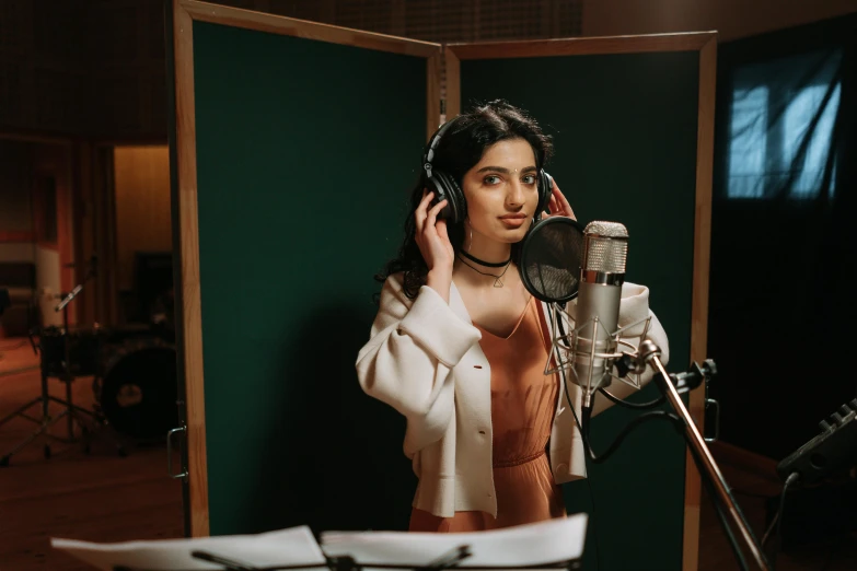 a woman standing in front of a microphone in a recording studio, an album cover, trending on pexels, hurufiyya, princess jasmine, thumbnail, actress, lily frank