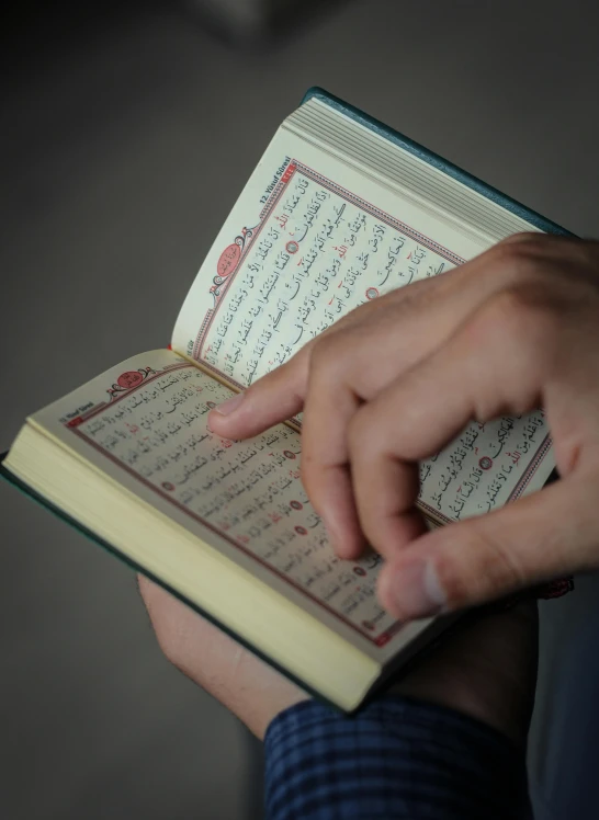 a close up of a person holding a book, hurufiyya, teaching, square, high quality picture, small