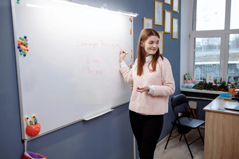 a woman writing on a white board in a classroom, by Emma Andijewska, pexels contest winner, danube school, model posing, olya bossak, eleanor tomlinson, 15081959 21121991 01012000 4k