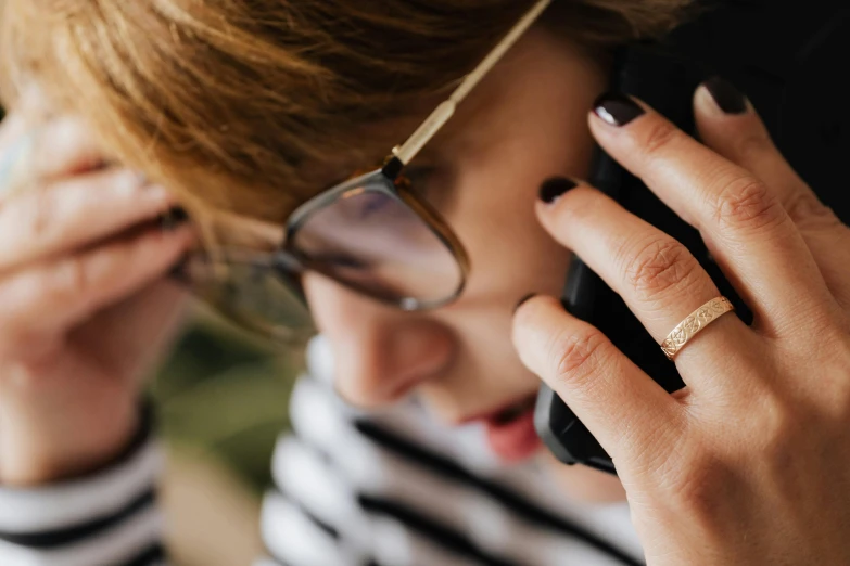 a close up of a person talking on a cell phone, by Julia Pishtar, trending on pexels, gold rings, girl with glasses, 15081959 21121991 01012000 4k, finely textured