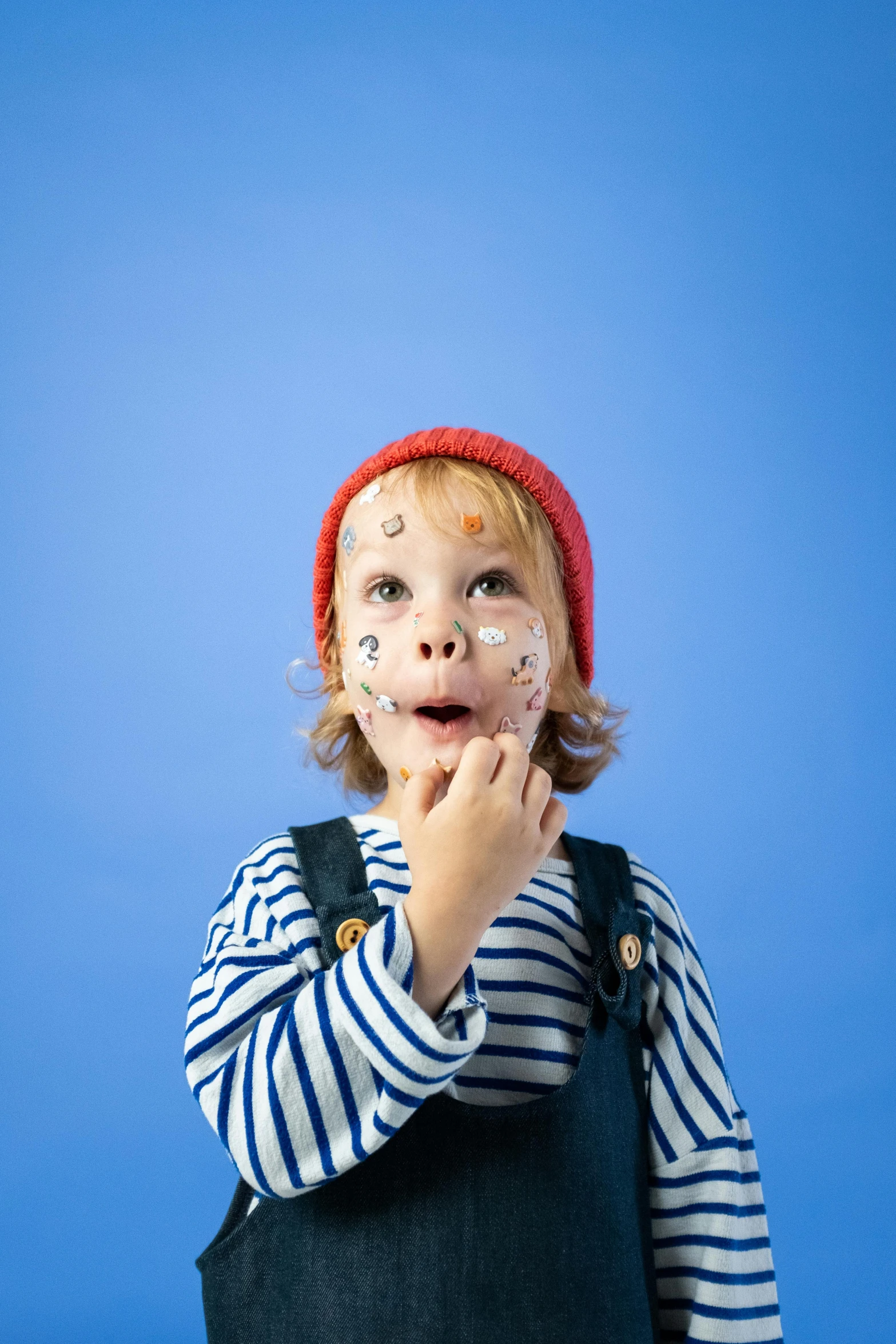 a little boy with food all over his face, inspired by Quentin Matsys, pexels, hyperrealism, with a blue background, wearing a french beret, spots, hey