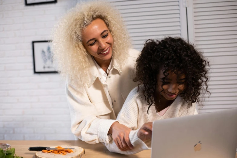 a woman and a child are looking at a laptop, trending on pexels, short blonde afro, charli bowater and artgeem, thumbnail, no cropping