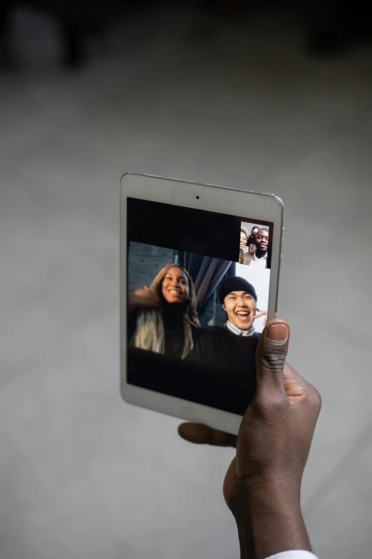 a person taking a picture of themselves on a tablet, by Nina Hamnett, unsplash, video art, in meeting together, square, photo of a black woman, waving