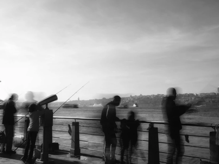 a group of people standing on top of a pier, a black and white photo, by Tamas Galambos, fishing, istanbul, blurry footage, eyelevel!!! view!!! photography