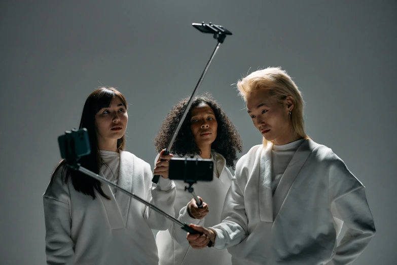 a couple of women standing next to each other, unsplash, realism, holding a staff, smartphone footage, three point lighting bjork, scientists