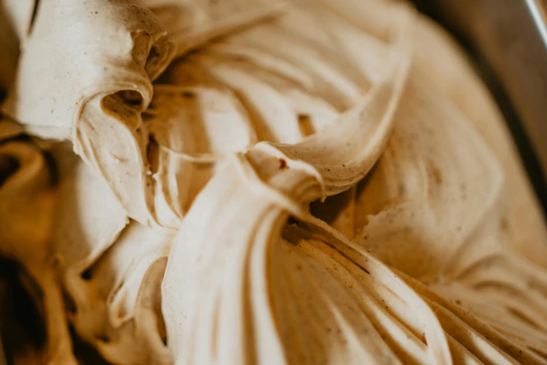 a close up of an ice cream in a bowl, by Daniel Lieske, trending on pexels, visual art, intricate wrinkles, background image, dough sculpture, draped in silky gold