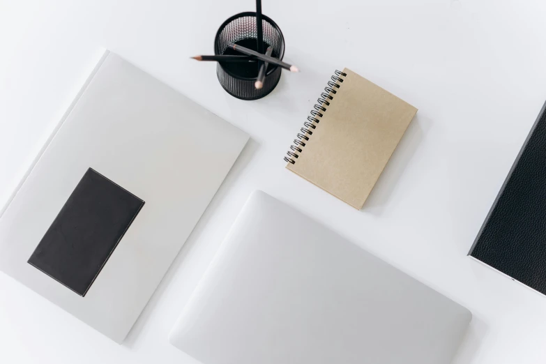 a laptop computer sitting on top of a white desk, trending on unsplash, minimalism, silver，ivory, graphite, pencil and paper, 9 9 designs
