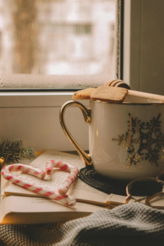 a cup sitting on top of a table next to a window, candy canes, thumbnail, honey, thin gold details