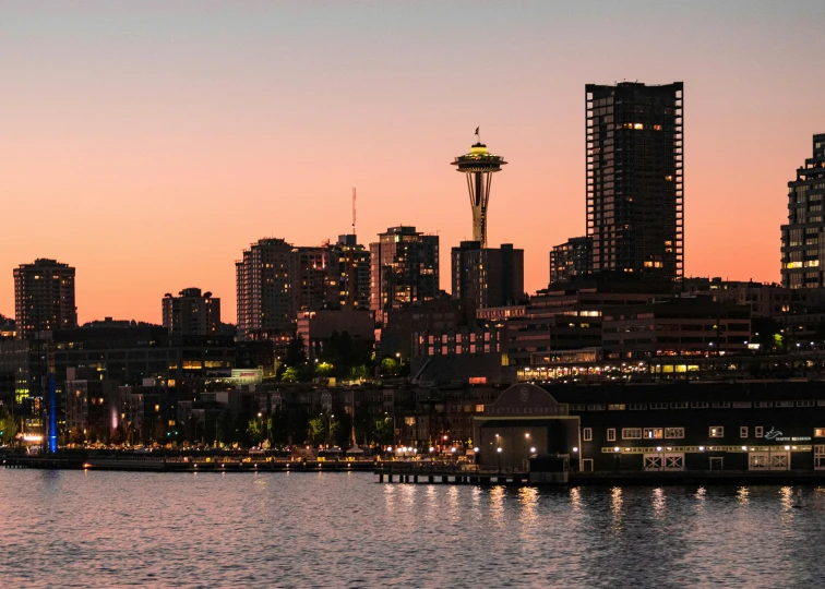 a large body of water with a city in the background, by Jason Felix, pexels contest winner, the space needle, pink golden hour, slide show, 2 0 2 2 photo