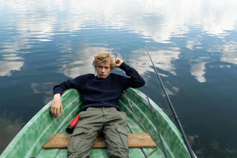 a man that is sitting in a boat, inspired by Nikolaj Abraham Abildgaard, trending on pexels, teenage boy, corduroy, press shot, ignant