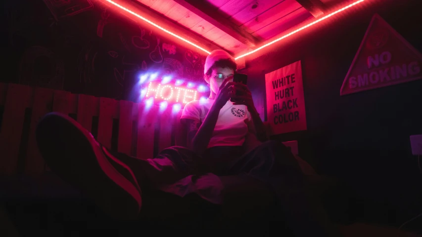 a man sitting in front of a neon sign, pexels contest winner, hotel room, ((pink)), white neon, red and obsidian neon