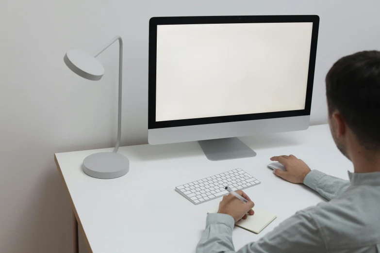 a man sitting at a desk in front of a computer, a computer rendering, by Carey Morris, pexels contest winner, white space, minimalissimo, computer mouse, white finish