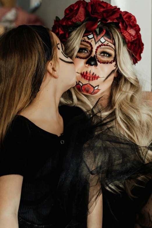 two women wearing day of the dead makeup, by Julia Pishtar, trending on pexels, portrait of two girls kissing, a blond, gif, motherly