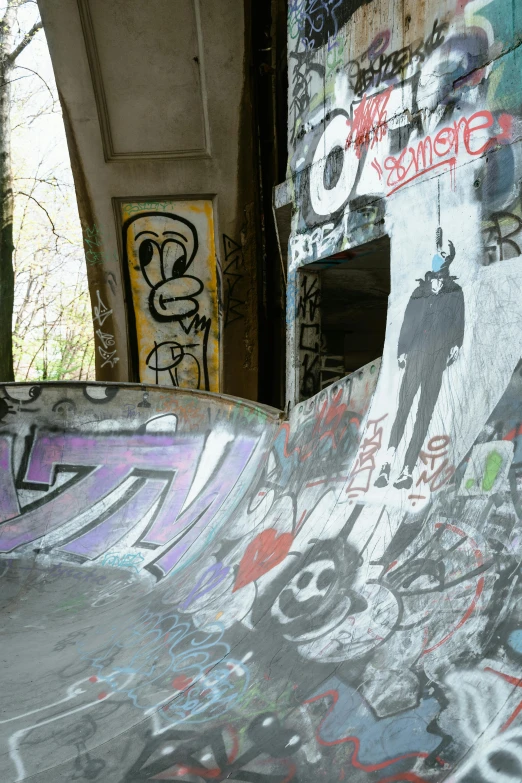 a man riding a skateboard up the side of a ramp, graffiti, les catacombes, wrecked buildings, slide show, indoor picture