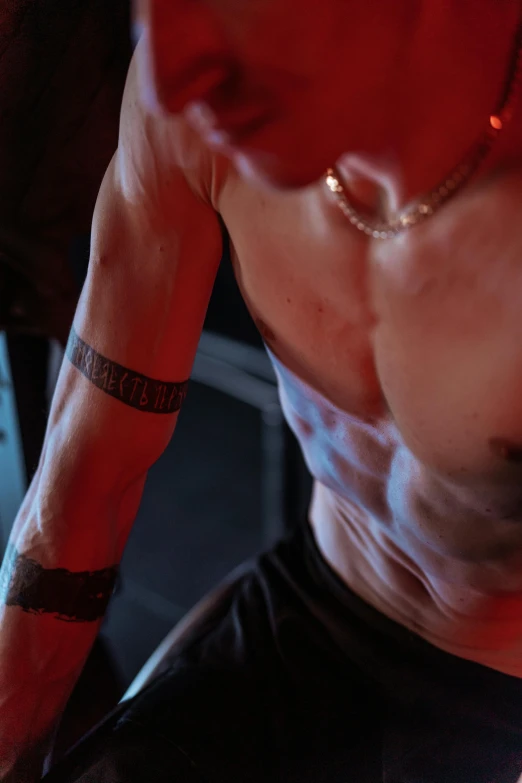 a shirtless man sitting in front of a laptop computer, a tattoo, reddit, vfx action shot, closeup of arms, with glowing runes on the body, promo image