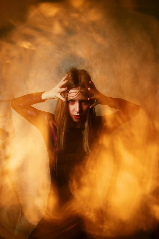 a woman sitting in front of a fire with her hands on her head, inspired by Brooke Shaden, renaissance, looking threatening, mystical orange fog, teenage girl, her hair is on fire