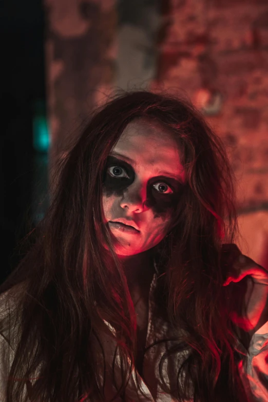 a woman dressed as a zombie standing in front of a brick wall, pexels contest winner, ariana grande as a sith, spooky found footage, red contact lenses, #trending