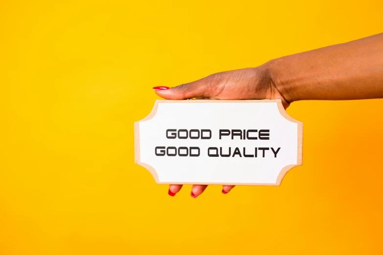 a woman's hand holding a sign that says good price good quality, pexels, pop art, hasselblad quality, thumbnail, brown, prince