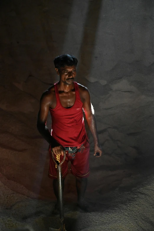 a man that is standing in the dirt, samikshavad, standing in a dimly lit room, holding a hammer, sweat and labour, production photo