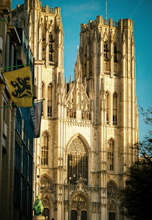 a large cathedral towering over a city street, a photo, by Barthélemy d'Eyck, belgium, neo - gothic architecture, “ golden chalice, banner