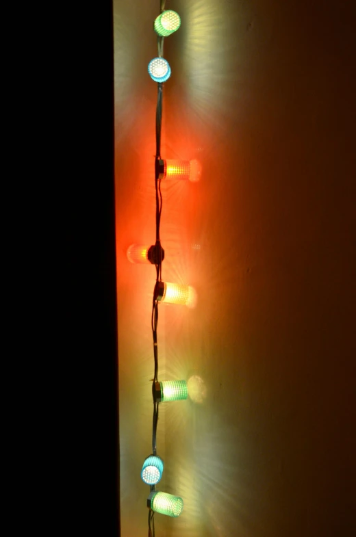 a wall that has a bunch of lights on it, an album cover, by Doug Ohlson, flickr, close-up shot taken from behind, red green, made of glowing wax and ceramic, light lighting side view