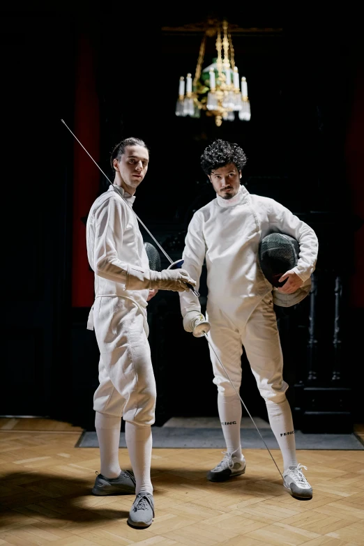 a couple of men standing next to each other on a wooden floor, inspired by Horace Vernet, renaissance, fencing, still from a wes anderson film, finn wolfhard, white uniform