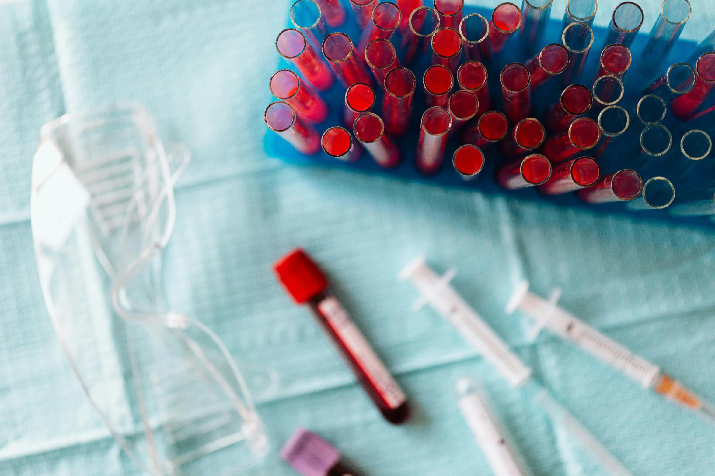 a bunch of tubes sitting on top of a table, a picture, by Emma Andijewska, pexels, blood smear, red cross, maroon and blue accents, scientific equipment