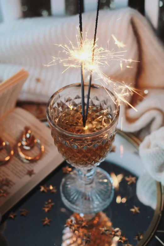 a glass filled with sparklers on top of a table, renaissance, winter vibes, with ornate jewelled, honey, profile image