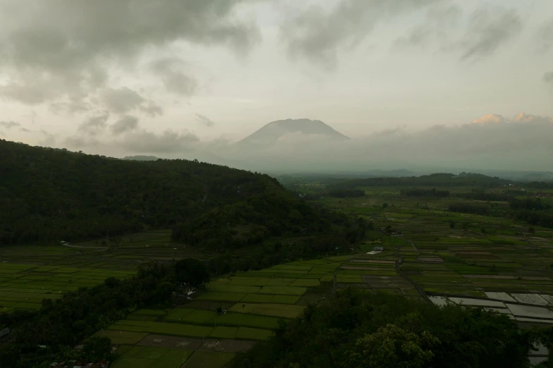 a view of a valley with a mountain in the distance, by Basuki Abdullah, overcast lighting, fan favorite, volcano, lut