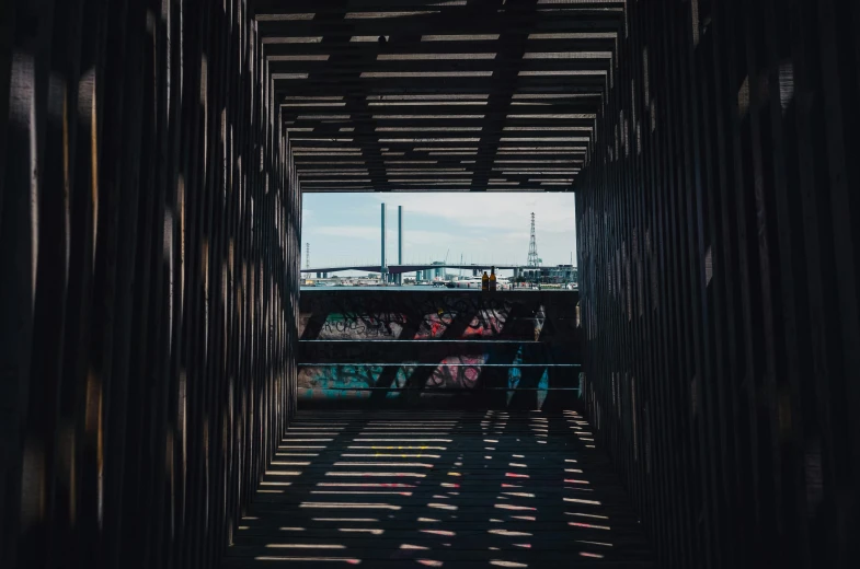 a couple of people that are standing in a tunnel, pexels contest winner, graffiti, skyline in the distance, detailed shadows, wooden structures, rectangle