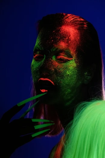 a woman with green paint on her face, an album cover, inspired by Ren Hang, trending on pexels, gel lighting neon glow, modeling photograph kerli koiv, black light, green and red