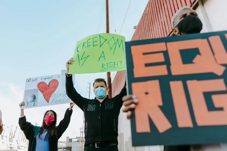a group of people holding signs in the air, by Ric Estrada, pexels, excessivism, teddy fresh, reddish, profile image, emir