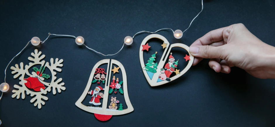 a close up of a person holding a christmas ornament, a cartoon, pexels, folk art, led light strips, wooden decoration, diecut, half - turn